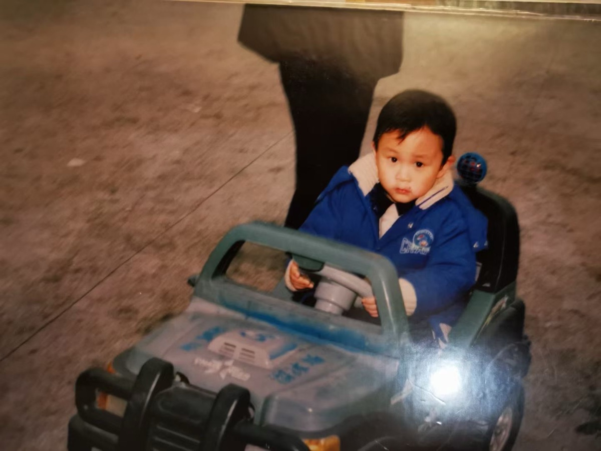 Childhood photo driving a toy jeep